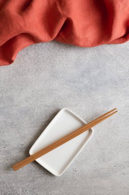 Terracotta peçetesi ve bambu çubuklu boş dikdörtgen tabak.