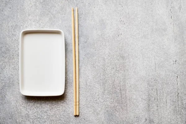 Empty Rectangular Plate Bamboo Chopsticks Gray Background Copy Space — стоковое фото
