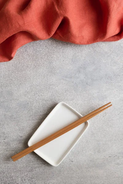 Terracotta Napkin Empty Rectangular Plate Bamboo Chopsticks Concrete Background Copy — стоковое фото
