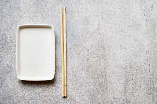 Empty Rectangular Plate Bamboo Chopsticks Gray Background Copy Space Stockbild