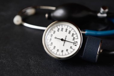 Karanlık arkaplanda sphygmomanometre veya tonometre yakın plan, alanın sığ derinliği