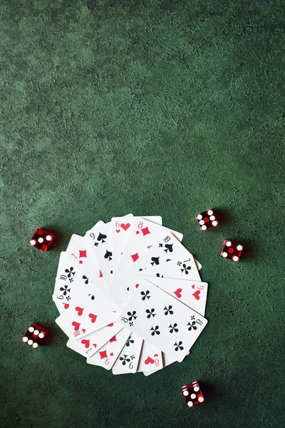 カジノのコンセプトは 緑のテーブルの上のビューに円とサイコロに配置されたカードを再生する — ストック写真