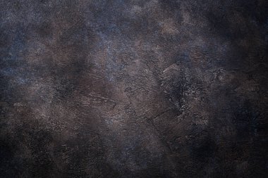 Bakır tonlarda eski beton bir duvarın pürüzlü koyu dokusu.