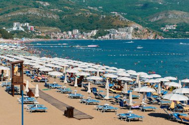 Becici tatil beldesindeki güneş şemsiyeleri, güneşlikler ve deniz manzarası: Karadağ, Becici - 12 Ağustos 2017