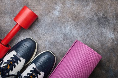 Spor ayakkabısı, dambıl ve spor paspası, sağlıklı bir yaşam konsepti.