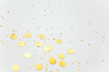 Beyaz arka planda altın konfeti ve parıldayan yıldızlar