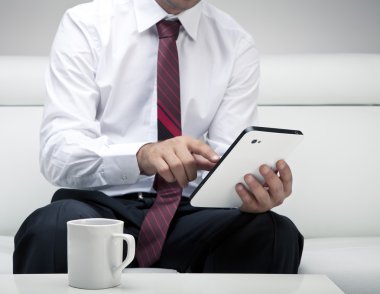 Tablet üzerinde çalışan iş adamı