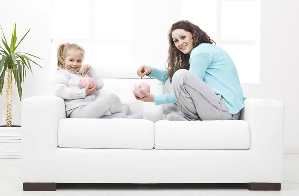 Anne ve kızı kanepe üzerinde tasarruf hakkında bilgi edinin — Stok fotoğraf