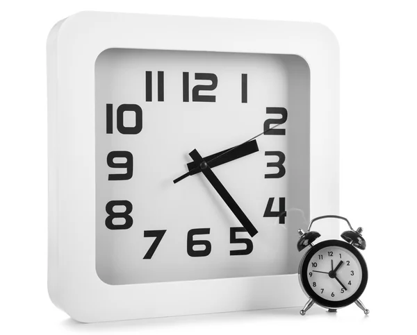 White wall clock and black alarm clock — Stock Photo, Image