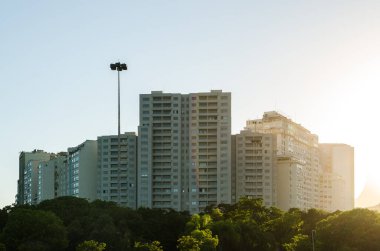 Sunset 'teki ağaçların tepesindeki apartman daireleri.