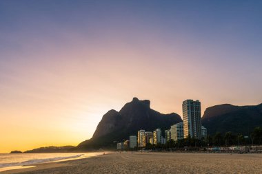 Rio de Janeiro 'daki Boş Sao Conrado Plajı' nda gün batımında lüks apartmanlar ve Pedra da Gavea Manzarası