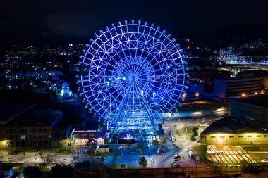 Rio de Janeiro, Brazil - August 3, 2022: Yup Star (Rio Star) ferris wheel at night is illuminated with colorful RGB led lights.
