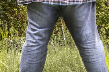 Man peeing on a meadow clipart