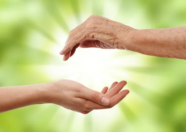 Young hand holding and elder one — Stock Photo, Image