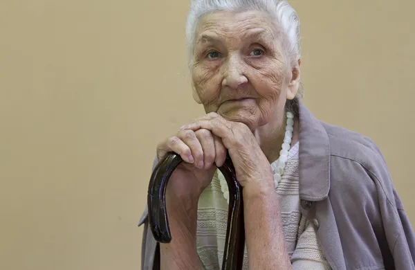 Triste signora anziana contemplando con bastone da passeggio — Foto Stock