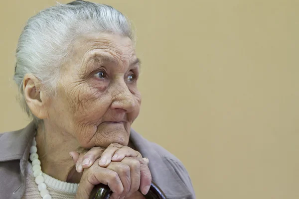 Triste vieille dame contemplant avec bâton de marche — Photo