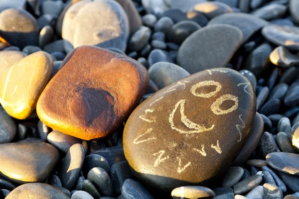 Stone with a painted face — Stock Photo, Image