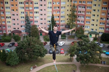 LUBIN, POLAND - 25 Eylül 2021: Iwona Buczek Anıtı 'na tırmanma zorluğu. Gülümseyen bir ip cambazı yüksek irtifada ipte yürüyor..
