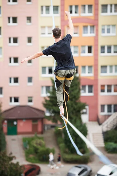A tightrope walker is walking on the rope at a high altitude.