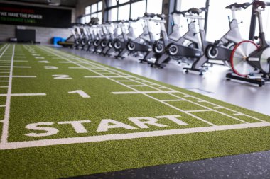Spor salonunda arka planda spor salonu olan yapay çimenler.