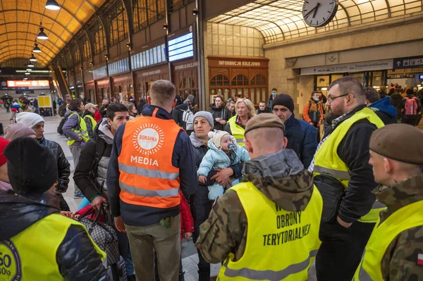 WROCLAW, POLAND - 4 Mart 2022 Wrocaw 'daki tren istasyonunda Ukraynalı savaş mültecilerine yardım. Resimli Polonyalı gönüllü ve mülteciler.