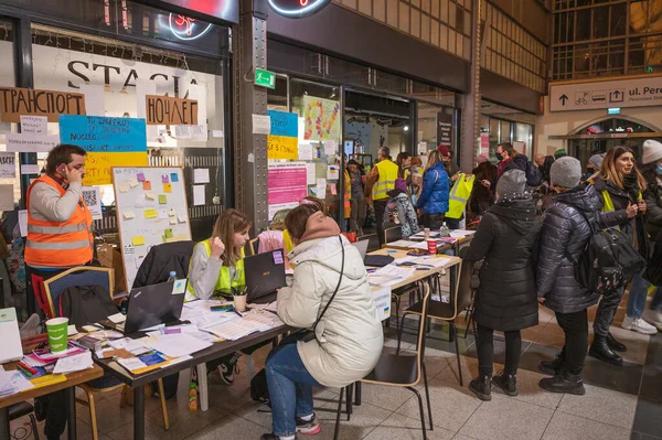 WROCLAW, POLAND - 4 Mart 2022 Wrocaw 'daki tren istasyonunda Ukraynalı savaş mültecilerine yardım. Resimli Polonyalı gönüllü ve mülteciler.