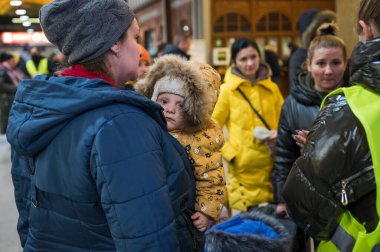 WROCLAW, POLAND - 11 Mart 2022: Wrocaw 'daki tren istasyonunda Ukraynalı savaş mültecilerine yardım. Fotoğraflı Polonyalı gönüllüler mültecilere yardım ediyor.