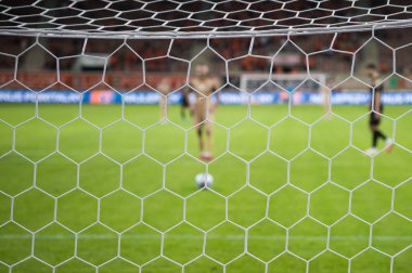 Arka planda futbolda kale penaltı atışları.