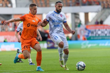 LUBIN, POLAND - 14 Mayıs 2022: KGHM Zaglebie Lubin ile Rakow Czestochowa 1: 0 arasındaki Polonya maçı. Eylemde Kacper Chodyna (L) ve Ivi Lopez (R)).
