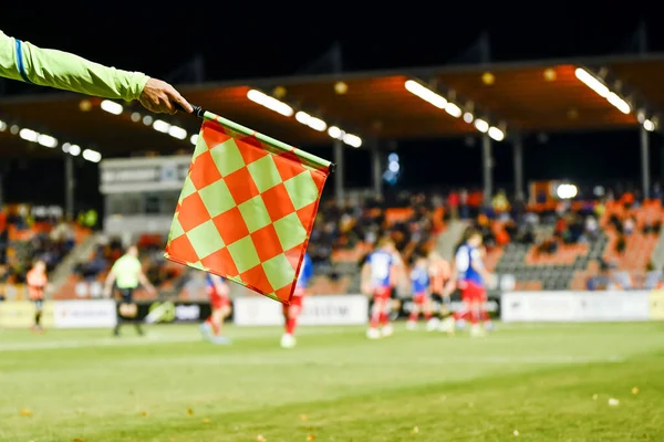 在足球场举行的比赛中 足球触控线裁判的旗子上挂着国旗 — 图库照片