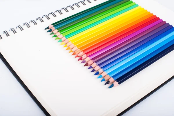 在一个笔记本上的彩色的铅笔 — 图库照片