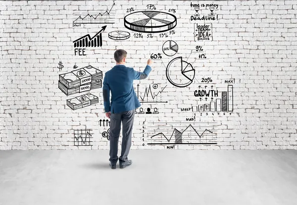 Business man drawing business plan, graph, chart on wall — стоковое фото