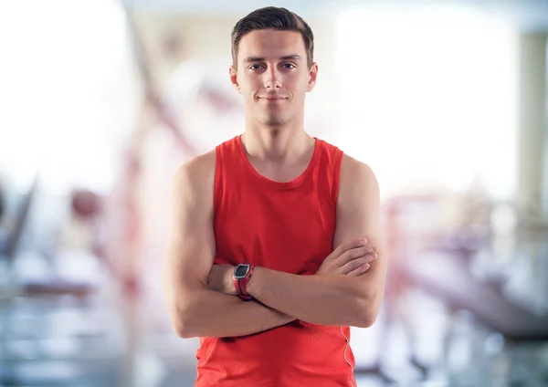 Parlak spor salonunda duran gülümseyen bir sporcu erkek eğitmen Koç portresi — Stok fotoğraf