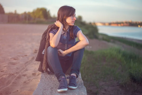 Hermosa modelo de mujer con el pelo largo vestido con jeans casuales, chaqueta de cuero. Belleza chica romántica al aire libre. Resplandor de verano luz solar. Puesta de sol de otoño. Sol. Tonificado colores cálidos . —  Fotos de Stock