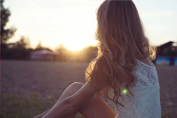 Słoneczny portret pięknej młodej kobiety romantyczne lub dziewczyna w białej sukni na plaży, obserwując zachód charakter korzystających letni wieczór na zewnątrz. Miękkie światło. słońce. stonowane kolory ciepłe. — Zdjęcie stockowe