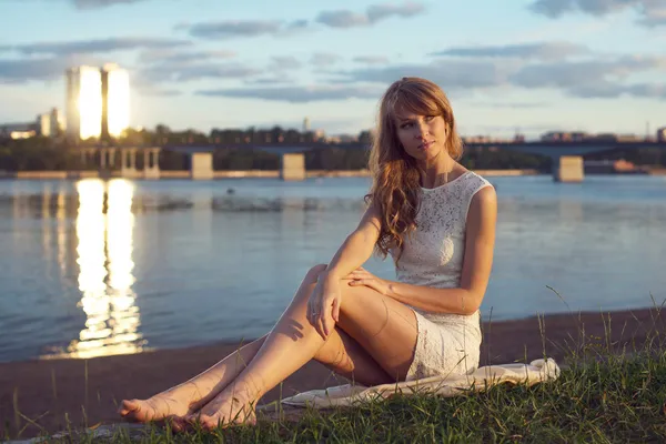 阳光明媚的户外的迷人浪漫的女孩，用长长的头发在夕阳下的画像。夏天晚上年轻漂亮的女人坐在一条河附近的海滩上。照片色调风格 instagram 过滤器 — 图库照片