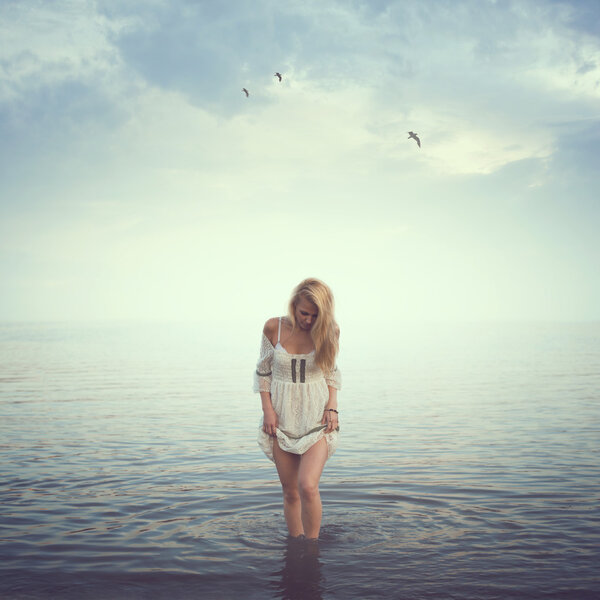 Schöne Mädchen im Wasser. Strand, Sonnenaufgang, kalter Morgen. Konzept Einsamkeit Liebe Traurigkeit Romantik — Stockfoto