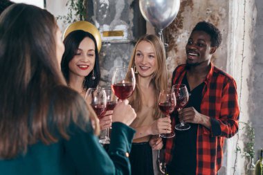 Arkadaşlar restoranda kutlama yaparken şarap içip kadeh kaldırıyorlar.