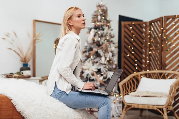 Νεαρή γυναίκα με φορητό υπολογιστή τα Χριστούγεννα — Φωτογραφία Αρχείου