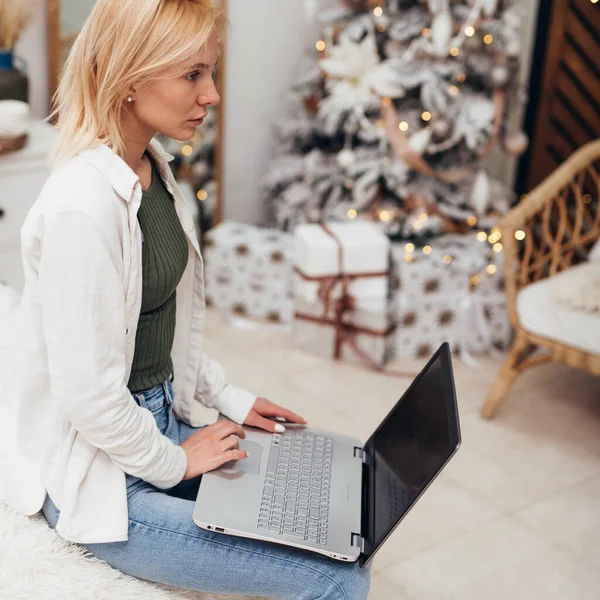 Ung kvinna med bärbar dator vid jul — Stockfoto