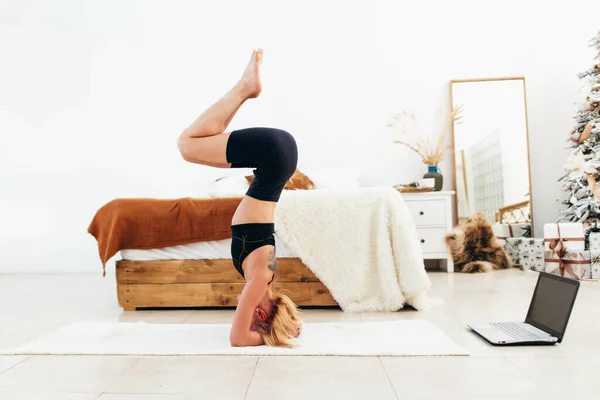 Genç, formda bir kadın evde amuda kalkma egzersizi yapıyor.. — Stok fotoğraf