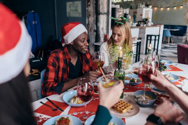 Die Menschen sitzen an einem festlichen Tisch und feiern Silvester oder Weihnachten. — Stockfoto