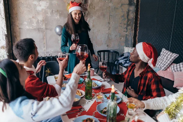 Люди сидят за праздничным столом и празднуют Новый год или Рождество — стоковое фото
