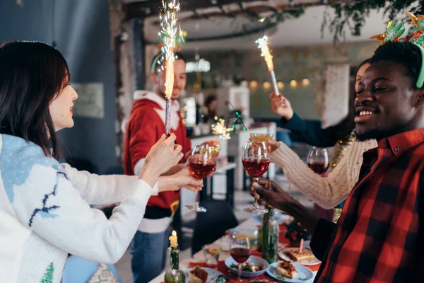 Amici multietnici che brindano al vino. Giovani uomini e donne che danno una festa al bar. Natale!. — Foto Stock