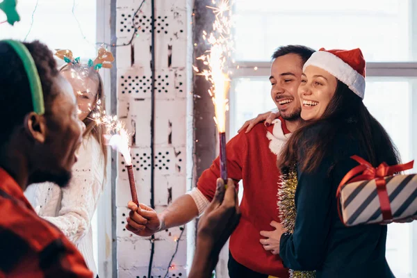 Vänner med tomtebloss i händerna. Vänner som firar julafton tillsammans. — Stockfoto