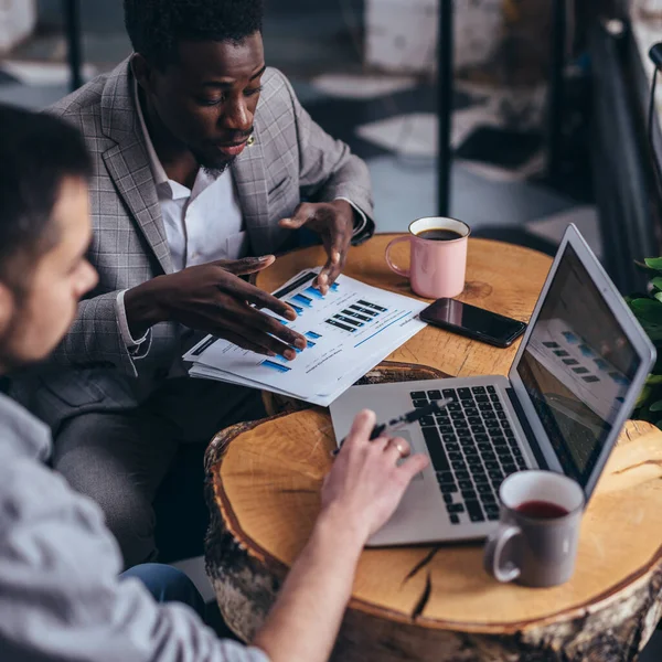 Business men review data at an informal cafe meeting — Stock Photo, Image