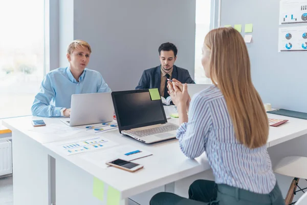 Kollegor diskuterar affärsidéer samtidigt som de samlas vid bordet och arbetar tillsammans. — Stockfoto