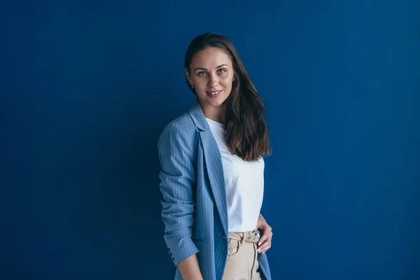 Retrato de mulher jovem em pé contra a parede com espaço de cópia e olhando para a câmera — Fotografia de Stock