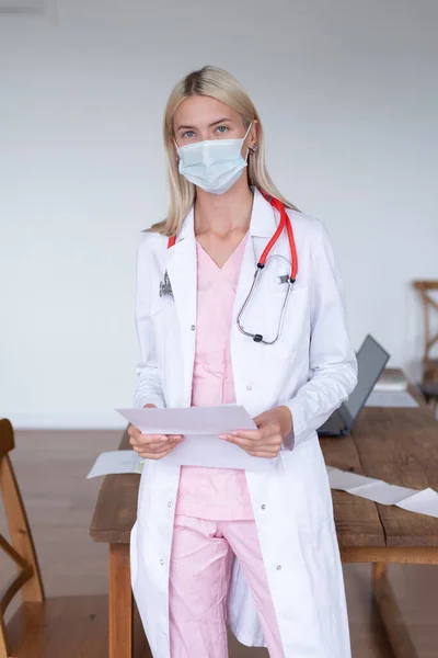 Portret van vrouwelijke arts in masker in het kantoor — Stockfoto