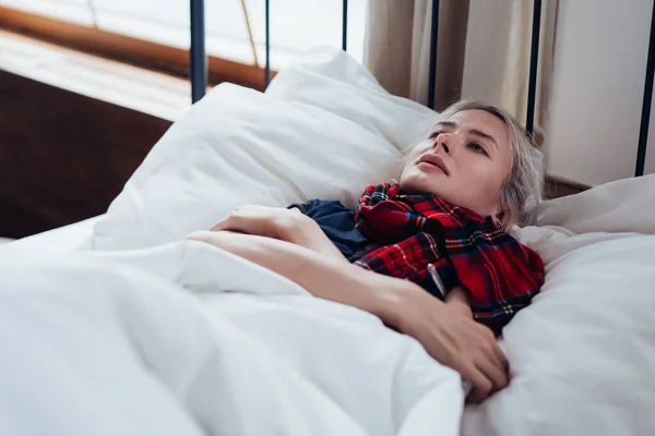 Mladá nemocná žena v posteli s mrazem — Stock fotografie